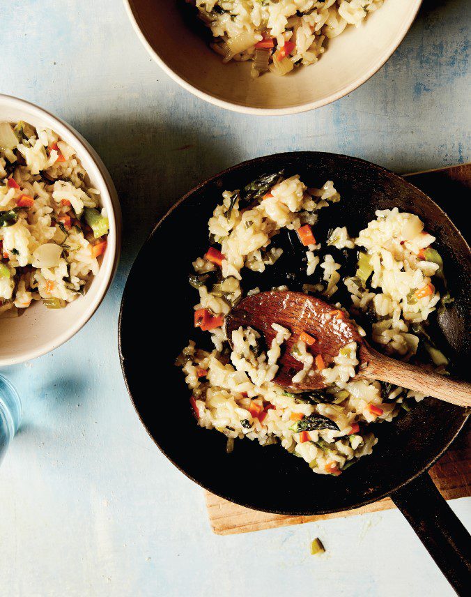 A cropped bowl and frypan, filled with colourful vegetable risotto.