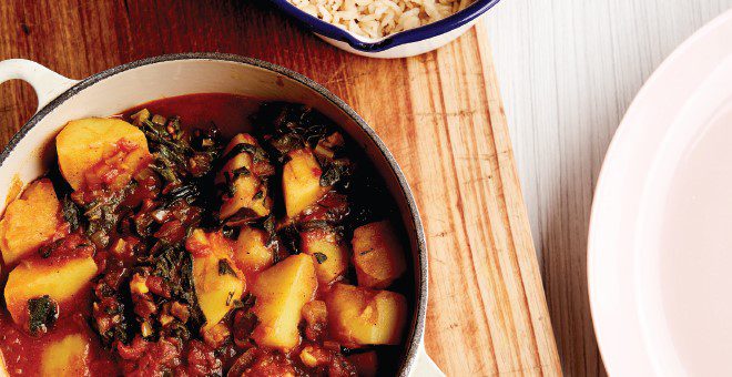 A large cast-iron pot filled with turmeric-toned vegetable curry.