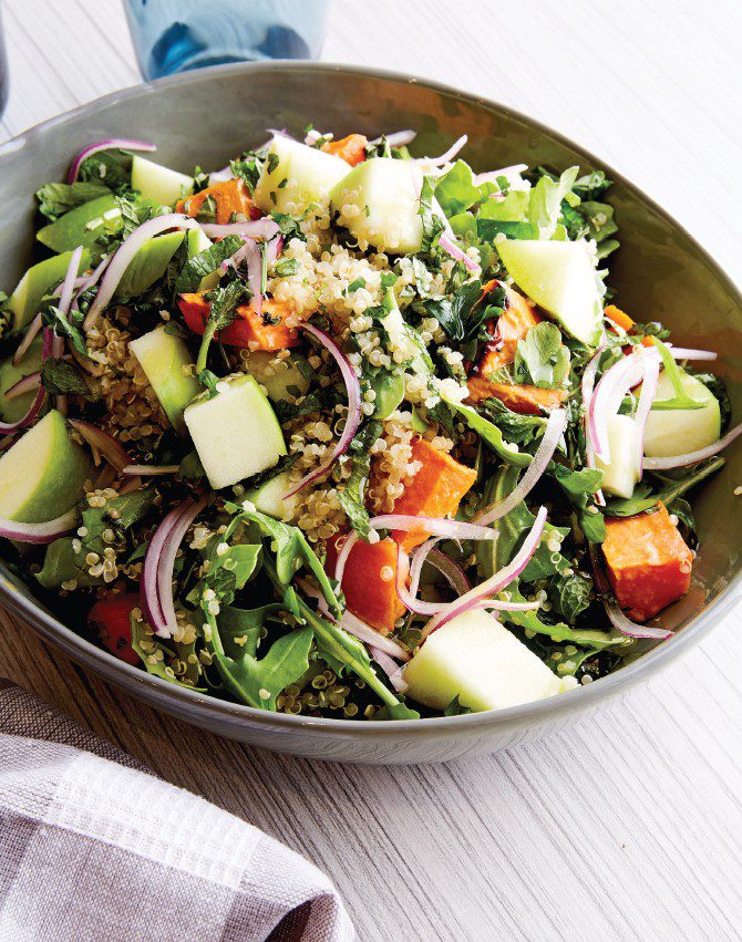 Fresh, vibrant salad leaves, mixed with quinoa and bright green apple chunks.